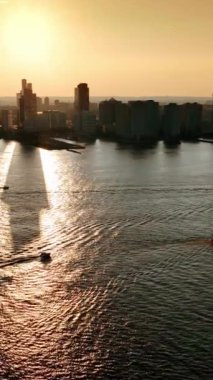 Görkemli New York 'ta altın saat. Tekneler Hudson Nehri 'ne gider. Arka planda gökdelenlerin siluetleri. Üst Manzara. Dikey video