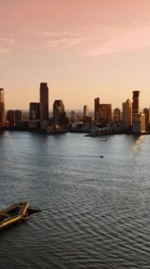 Battery Park City 'deki Hudson Nehri manzarası. Suda tekneler ve yatlar. New York 'un lüks gökdelenlerini tepeden görmek. Dikey video