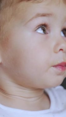 Beyaz erkek bebek yemek yemeyi reddediyor. Sevimli çocuk verilen kaşıktan başını çeviriyor. Kapatın. Dikey video