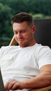 Kafkas sakallı, orta yaşlı bir adam laptopta çalışırken dikkatini dağıtıyor. Serbest çalışan bir iş adamı bir şeyler düşünürken kafasını çevirir. Dikey video