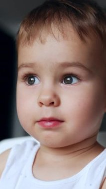 Güzel beyaz erkek bebek oyuncak yumurtalarla heyecanlı bir şekilde oynuyor. Oyuna odaklanmış bir çocuğun portresi. Kapatın. Dikey video