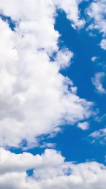 Kümülüs beyaz yumuşak bulutlar atmosferde hızla dönüşüyor. Düşük açı. Zaman Uygulaması.