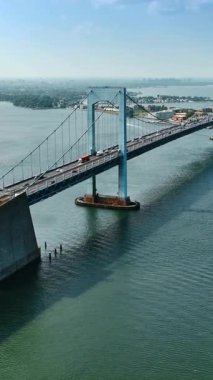 Arabalar East River üzerindeki asma köprünün yanından geçiyor. Güneşli bir günde New York 'taki Throgs Boyun Köprüsü' nün güzel manzarası.