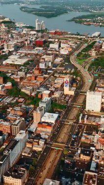 Gündüz vakti Philadelphia yollarında hareketli bir trafik var. Nehir ve köprü manzaralı geniş bir şehir manzarası..