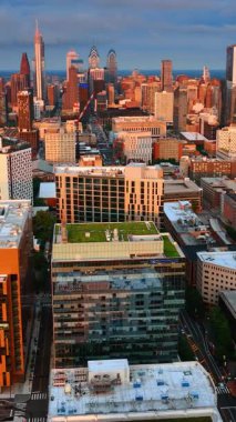 Philadelphia binalarının cepheleri batan güneşle aydınlandı. Gün batımında şehir panoramasının üzerinde İHA görüntüleri.
