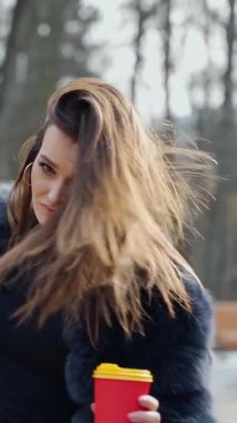 Parkta poz veren bir kadın. Doğada poz veren güzel genç bir kadın.