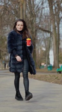 Kadınlar için moda açık hava manzarası. Harika park geçmişine karşı poz veren güzel bir kadının moda portresi.