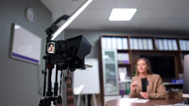 Modern Kafkasyalı blogcu profesyonel kamerada bir video kaydediyor. Düşük açı. Bloglama ya da video bloglama konsepti. Bulanık arkaplan.