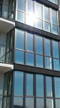 Yeni inşa edilmiş modern apartman cephesi. Çok katlı binanın dış cephesi. Şehir mimarisinin modern tasarımı. Hava görüntüsü. Dikey video