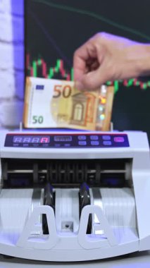 Sayma makinesine Euro para birimi. Makinede 50 Euro 'luk banknotlar sayılıyor. Sayma mekanizması avro işliyor. Dikey video