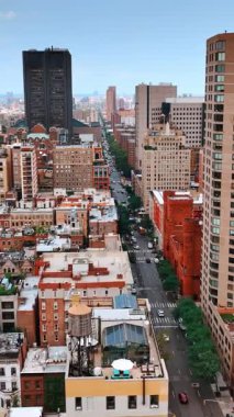 New York 'un çok katlı alçak binaları ve uzun otobanın üstünde uçuyorlar. Gündüz şehir panoraması. Dikey video