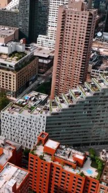 New York 'un rıhtımındaki yerleşim bölgesinin görüntüsü. Havadan bakıldığında güzel tasarlanmış binalar ve spor sahası. Dikey video
