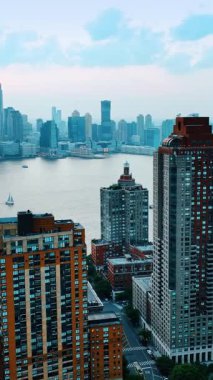 Nehrin karşısındaki New York gökdelenlerine bakıyorum. Hudson 'ın her iki tarafındaki görkemli bina. Nehir taşımacılığı suyun üzerinde. Üst Manzara. Dikey video