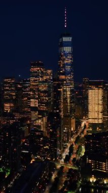 Milyarlarca ışığı olan canlı bir New York. İHA görüntüleri gece şehir manzarasının üzerine iniyor. Dikey video