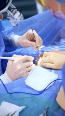 Metal alet ve elektrikli cihaz erkek cerrah tarafından kullanılır. Sıhhiye göğüs büyütme ameliyatı yapıyor. Dikey video.