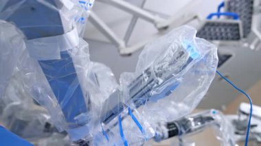 Kısırlık için plastik kaplı robot cerrahın manipülatör kolları. Da Vinci Cerrahi Sistemi 'nin çalışan kısımları iş başında. Düşük açı görünümü.