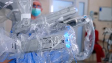 Plastik hareketlerle kaplı cerrahi sistemin robot kolları çalışıyor. Da Vinci makinesi en az invaziv ameliyatı yapar. Kapat..