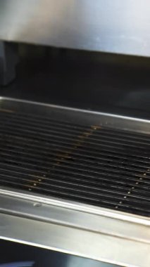 Restoranın mutfağında kızarmış et. Şef ızgarada taze et pirzolası yapıyor.