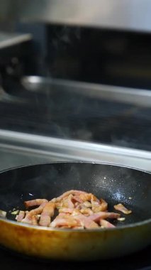 Şef restoranda yemek hazırlıyor. Aşçının elleri kızartma tavasında yemek pişiriyor.
