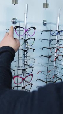 Adam dükkandan bardak alıyor. Yakışıklı adam gözlüğü mağazada ölçüyor.