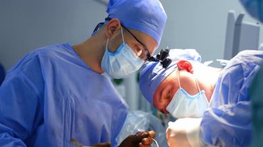 İki beyaz cerrah ameliyatta çalışıyor. Cerrahi hoparlörlerdeki beyin cerrahı modern aletlere sahip..