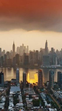 Manhattan 'ın üzerindeki bulutlu gökyüzü. New York şehir merkezi turuncu gün batımında. Üst Manzara. Dikey video
