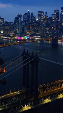 Geceleri muhteşem New York gökdelenlerinin açılışı. Metropolis 'in yol ve köprülerinde hareketli bir trafik var. Üst Manzara. Dikey video