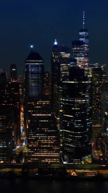 New York gökdelenleri rıhtım ışıklarıyla dolu. İHA görüntüleri binalardan uzaklaşıyor. Dikey video