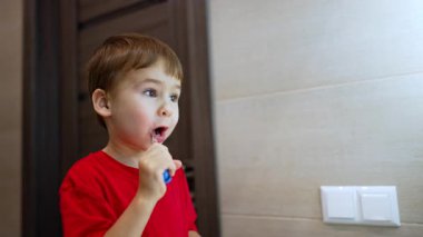 Sevimli beyaz erkek bebek dişlerini temizliyor. Mutlu çocuk dişlerini fırçalarken gülümsüyor..