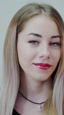 Güzel, gülümseyen kadın. Mükemmel makyajlı beyaz bir kadının güzel yüzü. Dikey video