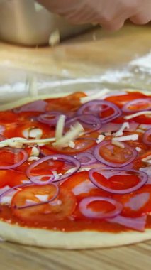 Pizza yapma süreci. Şef restoran mutfağında pizza hazırlıyor. Dikey video