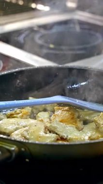 Demir tavada yemek kızartıyorlar. Şef restoranda büyük tavada yemek pişiriyor. Dikey video
