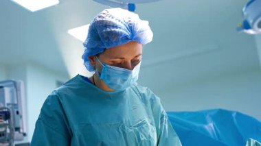 Operasyon için beyaz kadın doktor üniforması giymişti. Ameliyathanede çalışan bir cerrahın portresi.