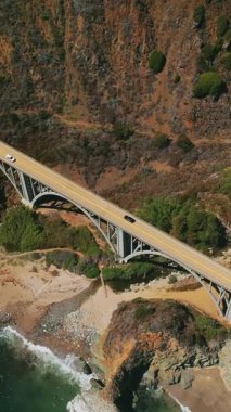 Kayalık arazideki büyük köprünün havadan görünüşü. Kaliforniya 'nın Big Sur kıyısındaki Bixby Creek Köprüsü. Dikey video