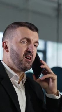 Zeki delikanlının telefonu var. Telefonla uğraşan kendine güvenen yakışıklı bir iş adamı. Dikey video