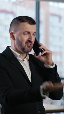 Telefonla uğraşan kendine güvenen yakışıklı bir iş adamı. Zeki delikanlının telefonu var. Dikey video