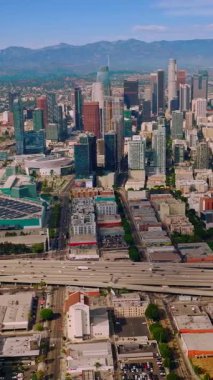 Los Angeles şehir binalarının gezici hava manzarası. Los Angeles şehir merkezindeki modern şehir. Dikey video