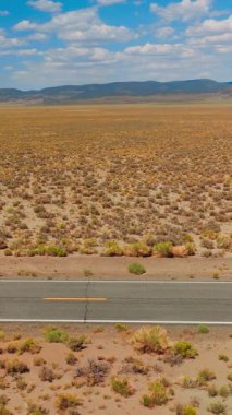 Çöl otoyolu araba sürücüsü. Nevada çöl yolu havadan çekilmiş. Dikey video
