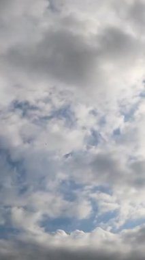 Yumuşak ışık bulutları koyu gri bulutlara dönüşür. Atmosferde yağmur oluşumu. Düşük açı. Zaman ayarlı. Dikey video