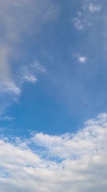 Atmosferde farklı türde bulutlar oluşuyor. Gökyüzünü kaplayan beyaz ışık bulutları. Düşük açı. Zaman ayarlı. Dikey video