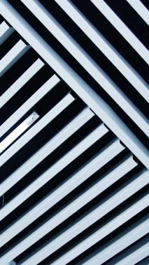 Tavanda standart olmayan beyaz kalaslar var. Kenarları arasında beyaz ışık olan uzun lambalar. Düşük açı. Dikey video