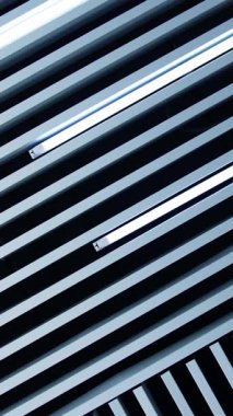 Odadaki tavanın alışılmadık tasarımı. Süslü kalasların arasında gün ışığı lambaları da var. Düşük açı. Dikey video