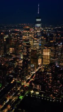 Geceleri göz kamaştırıcı New York manzarası. Metropolis milyarlarca ışıkla parıldıyor. Hava görüntüsü. Dikey video