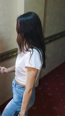 Bavullu şirin, mutlu bir kadın bir otel odasına giriyor. Mutlu tatiller için evden uzaklaşmaya hazır neşeli genç kız. Dikey video