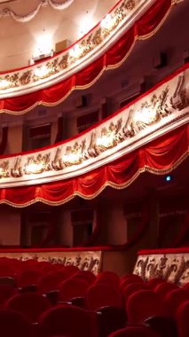 Güzel, zengin dekore edilmiş tiyatro salonunun panoramik manzarası. Tiyatroda kırmızı sandalyeler. İnsansız büyük boş bir tiyatro. Dikey video