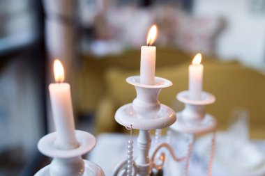 Samimi bir sofrada mum ışığında şık bir akşam yemeği. Yumuşak mum ışığı masanın üzerinde titreşiyor ve keyifli bir akşam yemeği deneyimi için sıcak bir ortam yaratıyor..