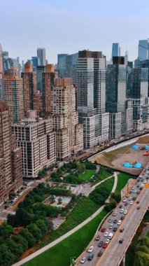 Doğu Nehri 'nin rıhtımına dizilmiş güzel binalar. İnsansız hava aracı New York 'ta yoğun bir trafik varken otoyolun üzerine iniyor. Dikey video
