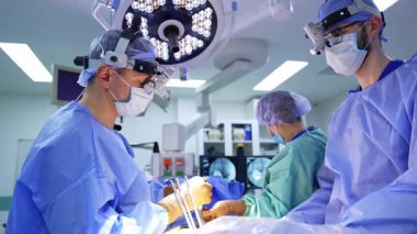 Ameliyat ekibi iş başında. Tıp uzmanları, bir hastaya çok önemli bir cerrahi işlem yapmak için bir ameliyathanede özenle çalışırlar..