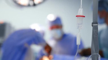 Modern bir ameliyathanede karmaşık bir ameliyat. Tıp uzmanları, parlak ışıklar altında steril bir ameliyathanede karmaşık bir cerrahi prosedür uyguluyorlar..