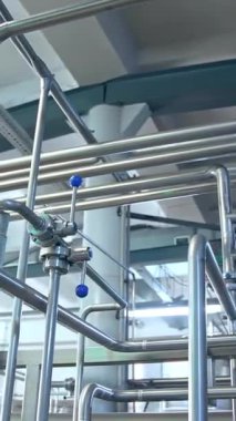 Süt ürünleri için büyük borular. Bir fabrikada süt ürünlerinin hazırlanması için büyük metal borular.